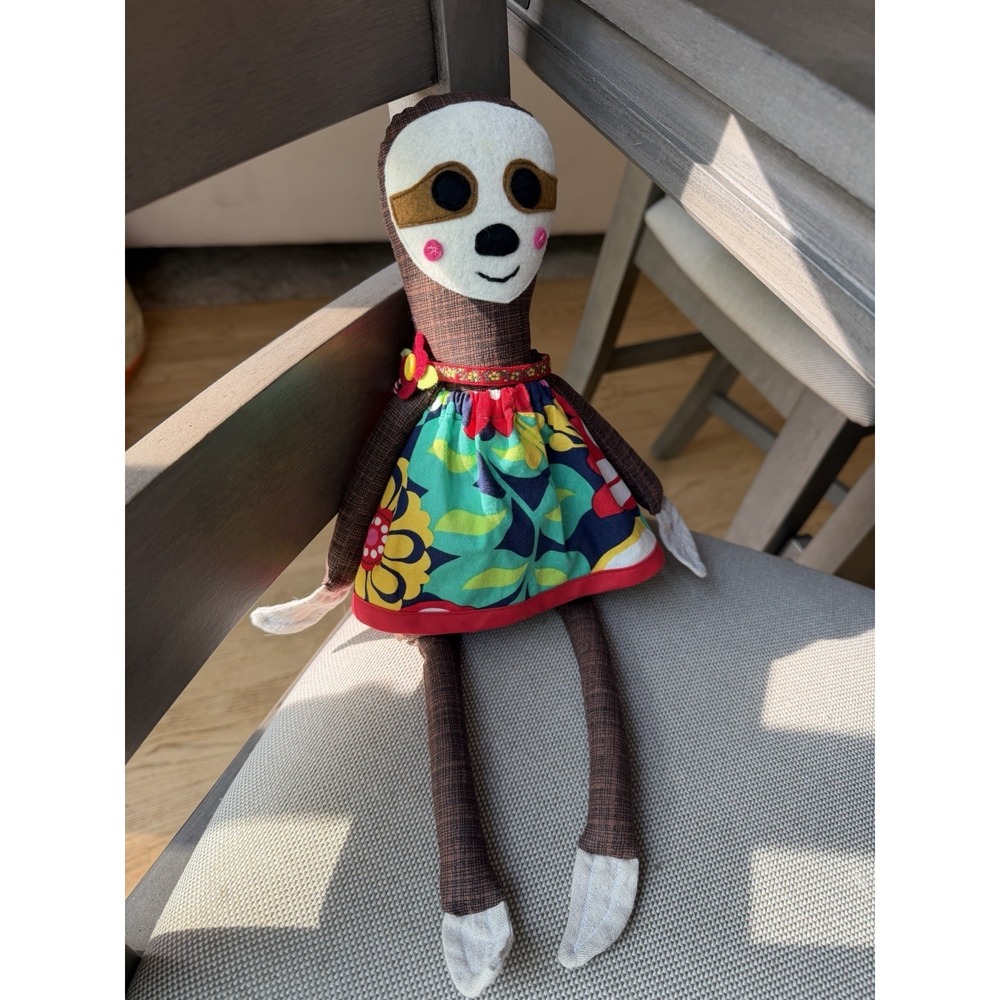 handmade fabric sloth doll featuring a vibrant floral dress.